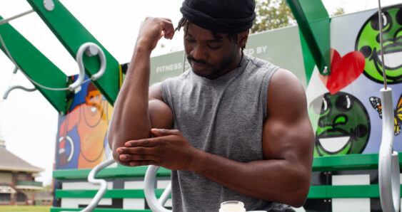 Man applying cream at outdoor gym