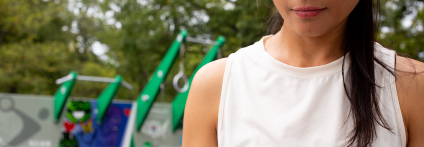 Woman holding skincare product outdoors