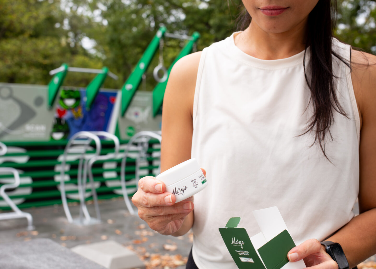 Woman holding skincare product outdoors