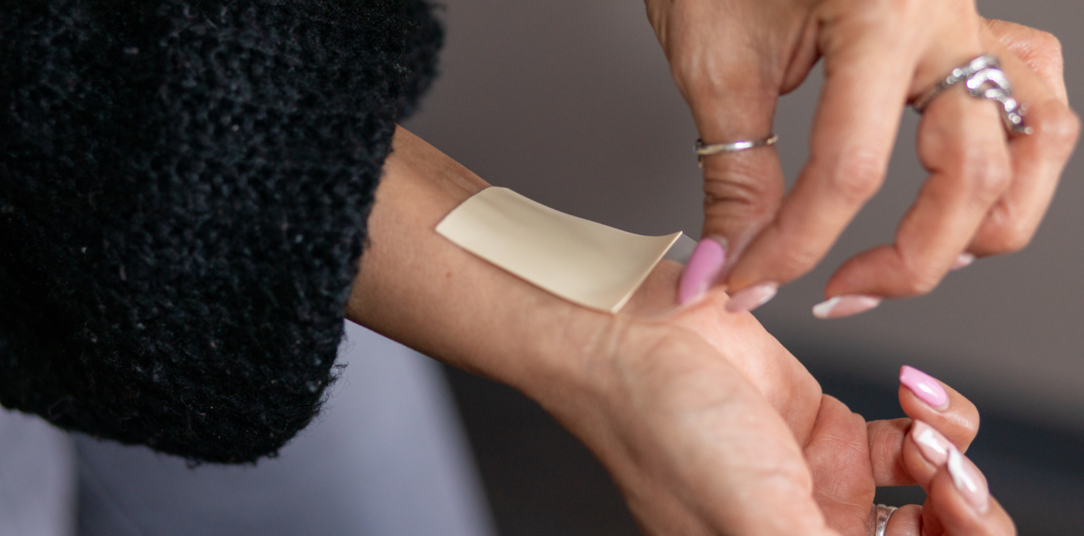 Applying adhesive patch on forearm skin