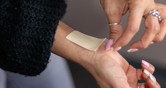 Applying adhesive patch on forearm skin