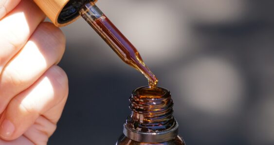 CBD oil dropper bottle in hand