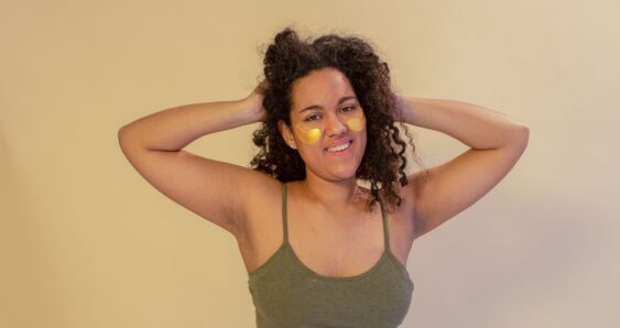 Woman with under eye patches smiling confidently