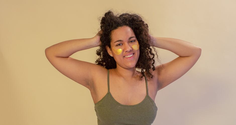 Woman with under eye patches smiling confidently