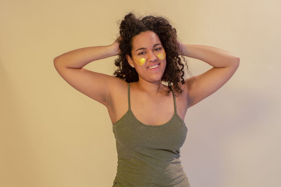 Woman with under eye patches smiling confidently