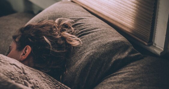 Woman sleeping peacefully on cozy bed pillow