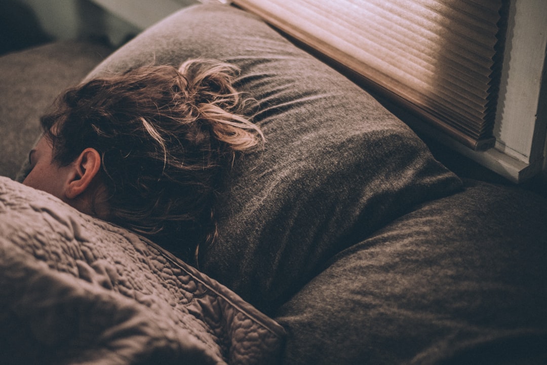 Woman sleeping peacefully on cozy bed pillow