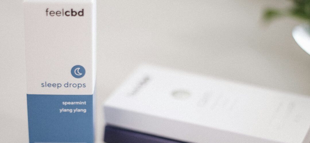 FeelCBD sleep drops box and vape pen on table